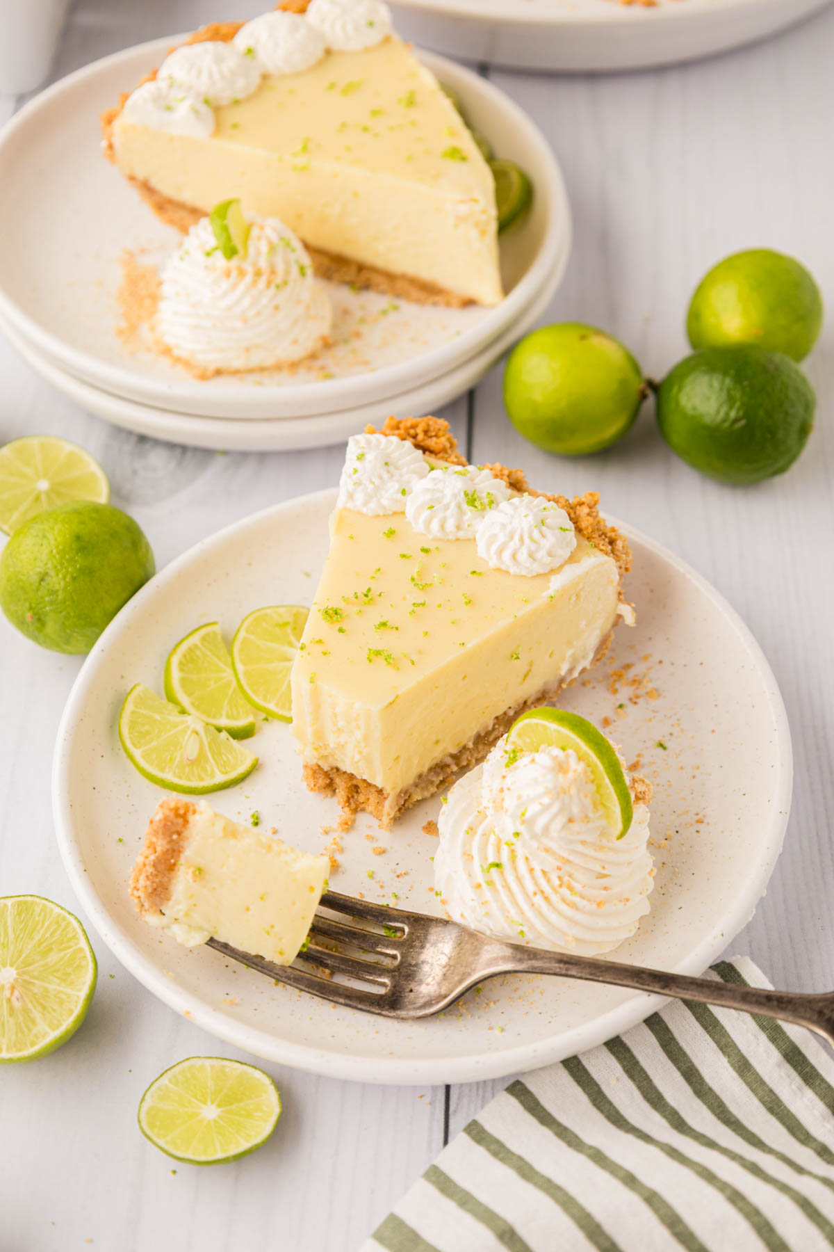 A slice of key lime pie with a bite removed with a fork.