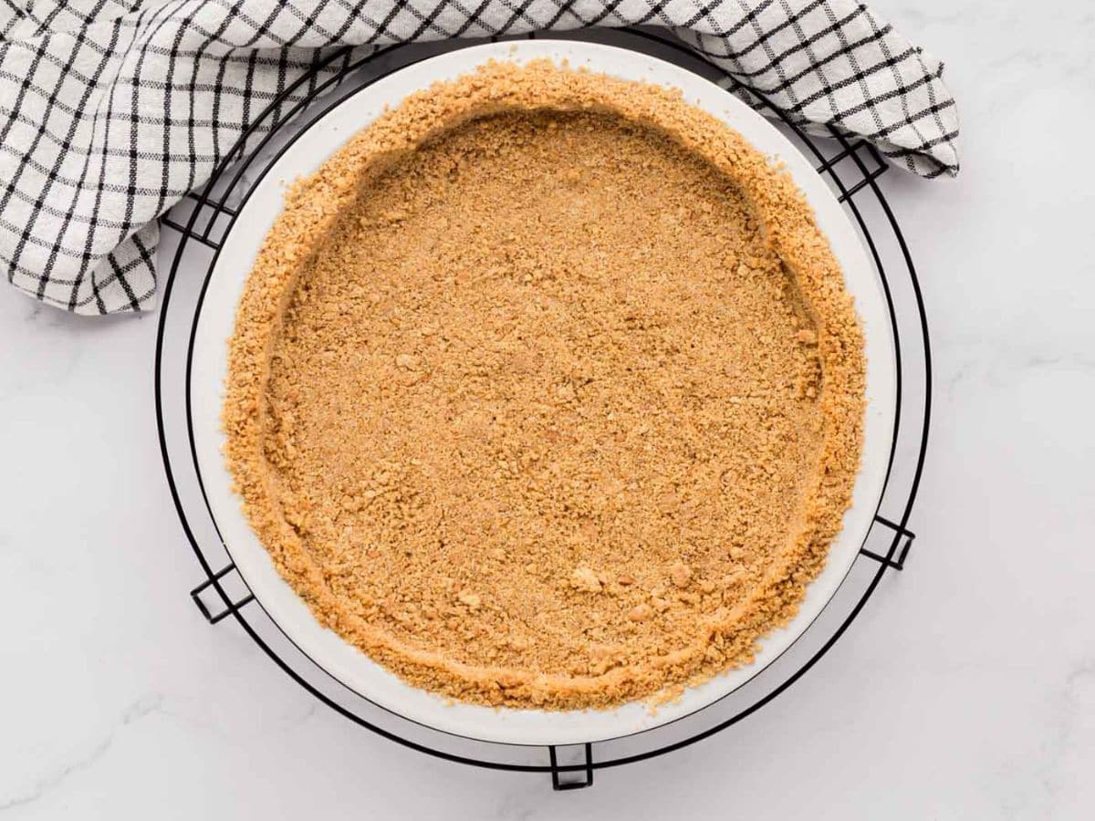 Graham cracker crust cooling on baking rack.