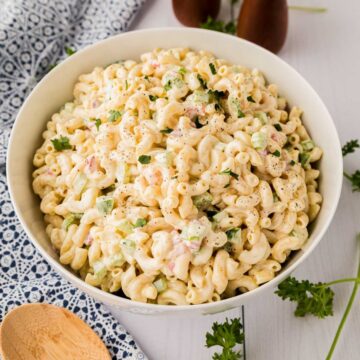 Large white serving bowl filled with homemade macaroni salad.