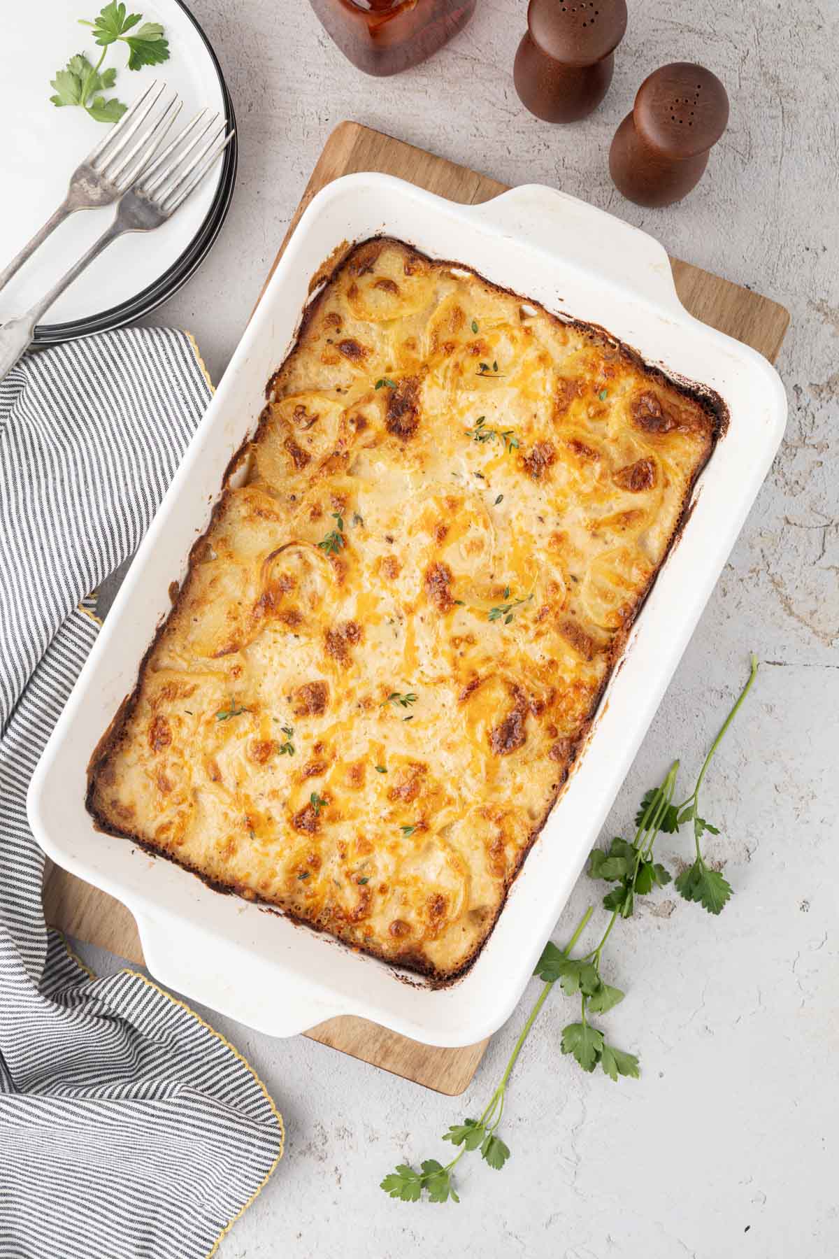 Overhead shot of baked scalloped potatoes in a white baking dish.