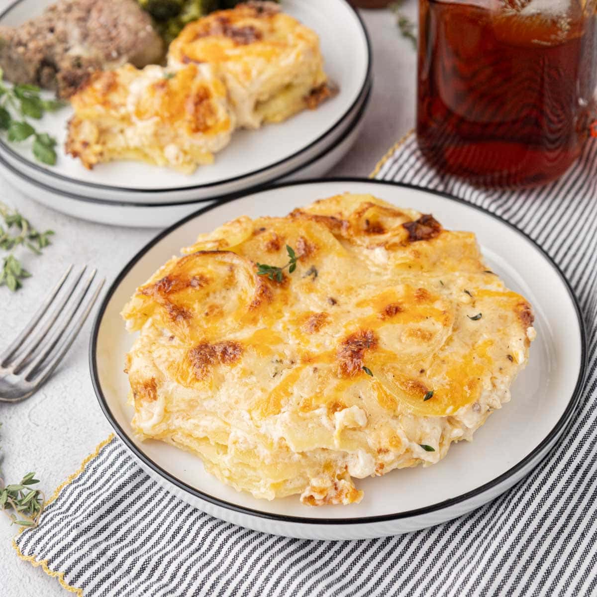 Portion of cheese scalloped potatoes on a white plate.