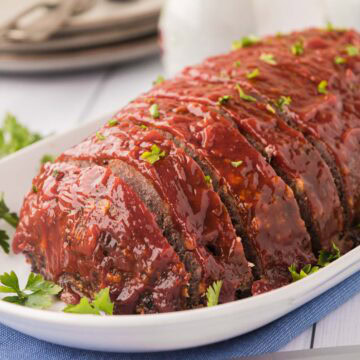 A classic meatloaf on a white serving platter.