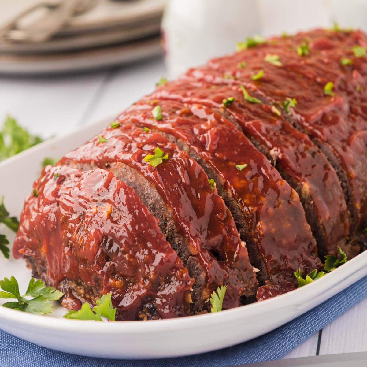 A classic meatloaf on a white serving platter.
