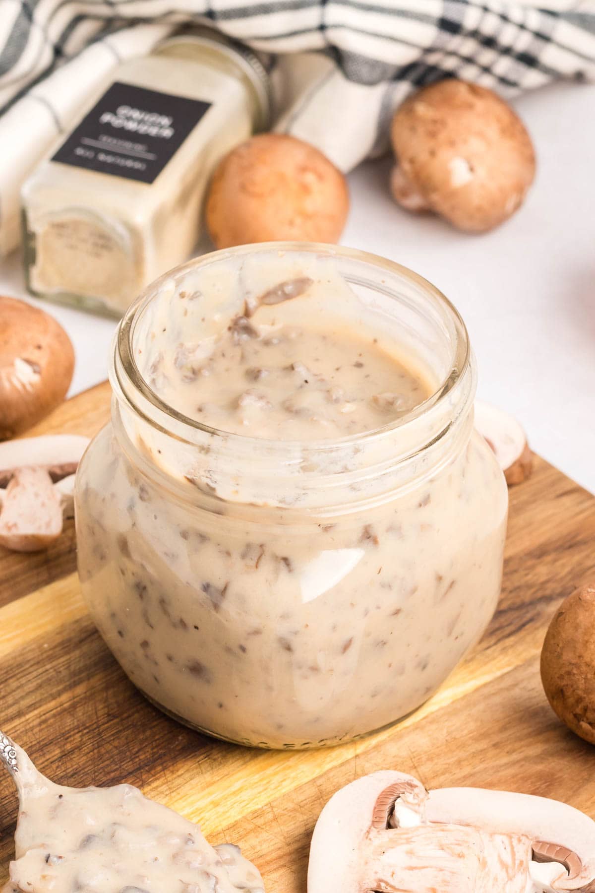 Homemade cream of mushroom soup in a jar on a wooden board.