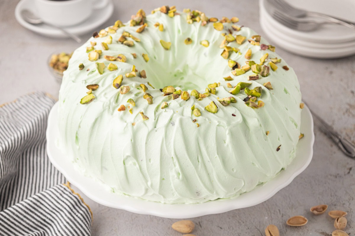 Pistachio bundt cake on a cake pedestal.
