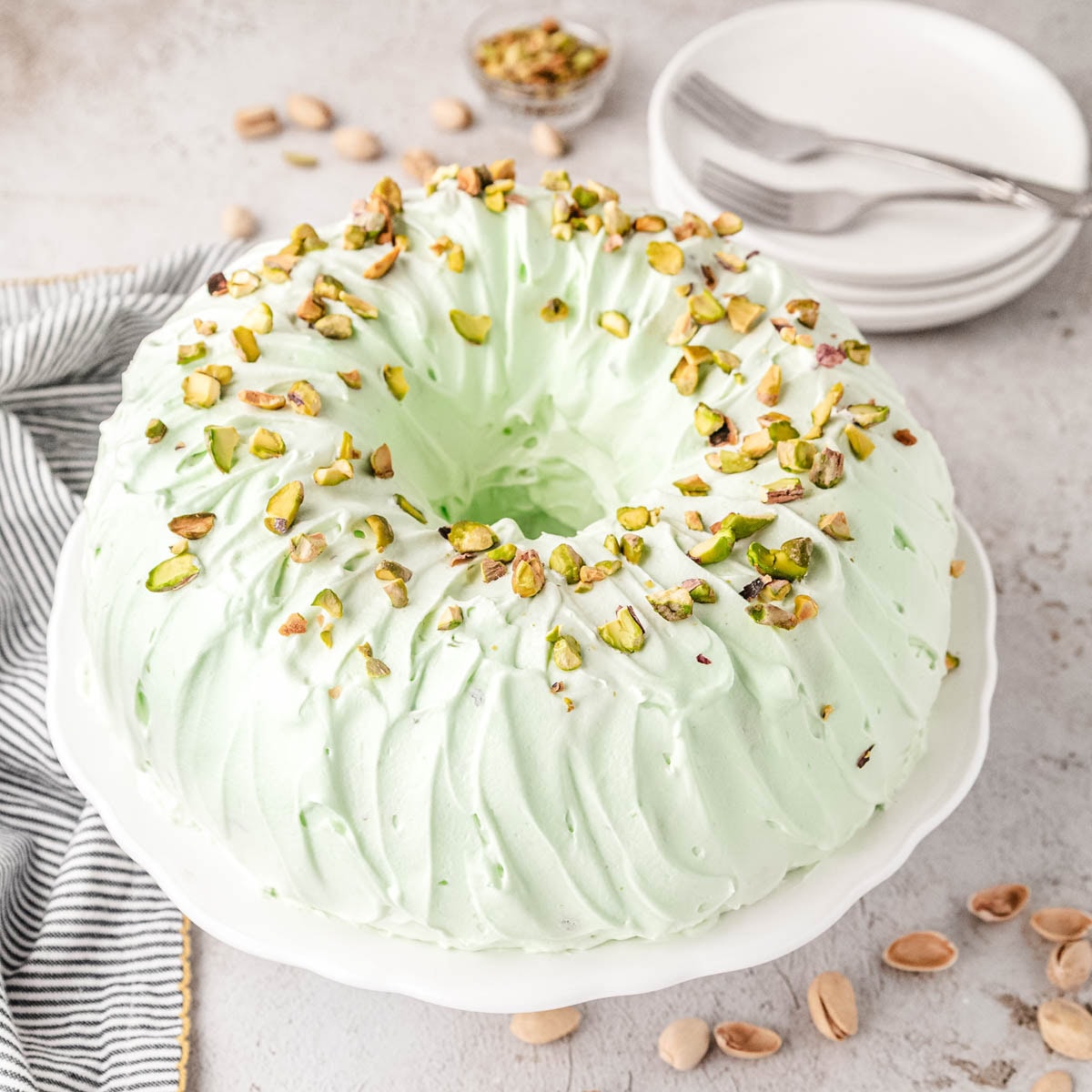Pistachio bundt cake on a cake pedestal.