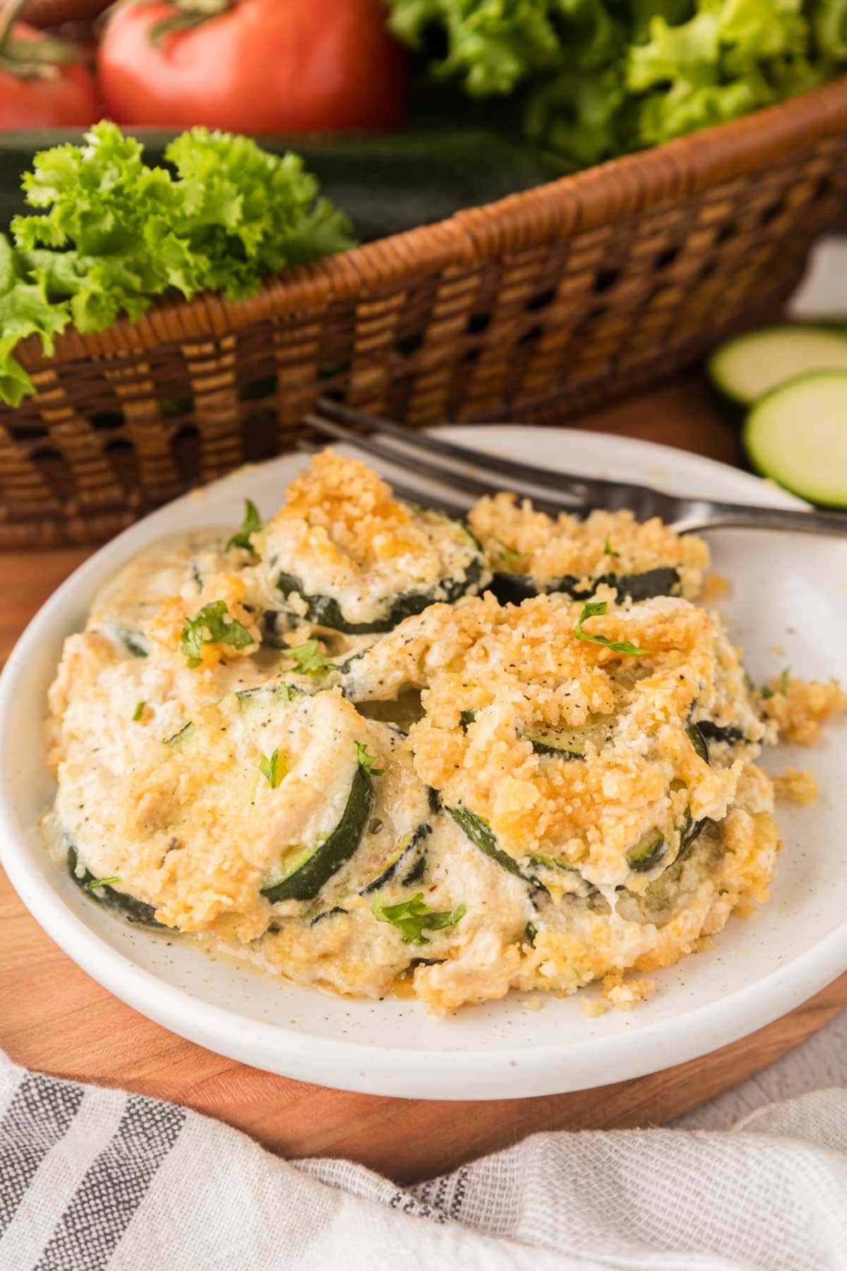 Portion of zucchini casserole served on a white plate with a fork.