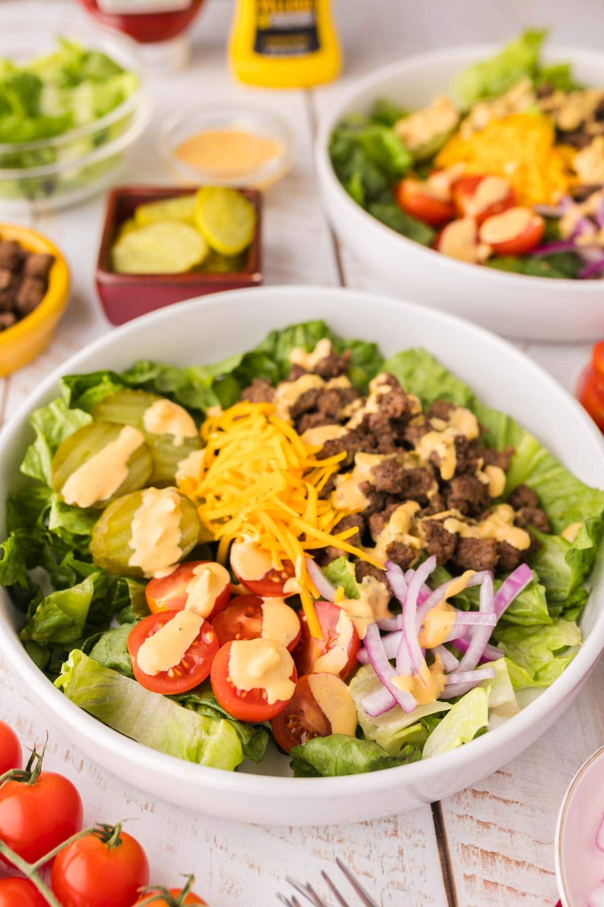 Big mac salad in a white bowl topped with dressing.