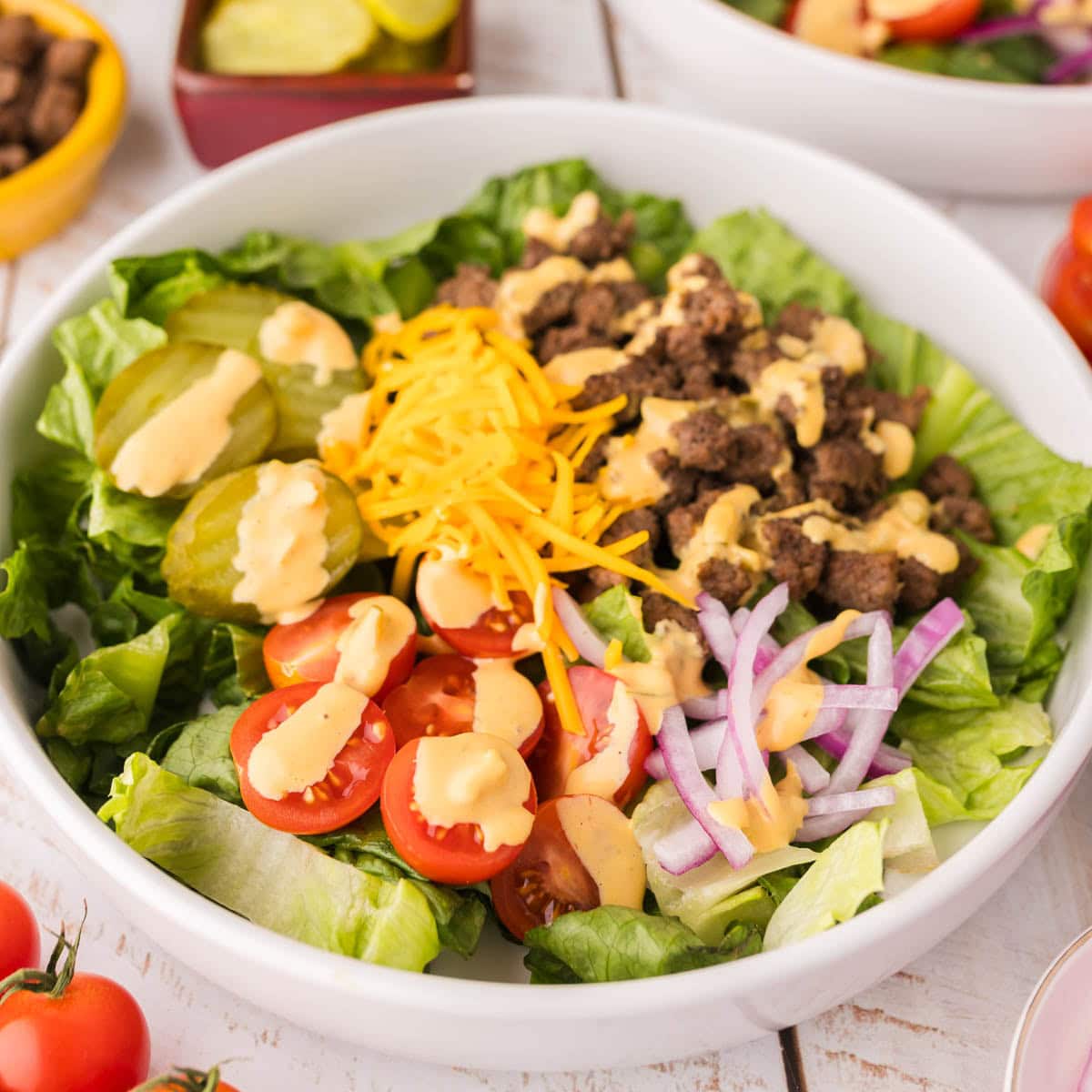 Close up of big mac salad cheeseburger bowl with drizzled sauce on top.