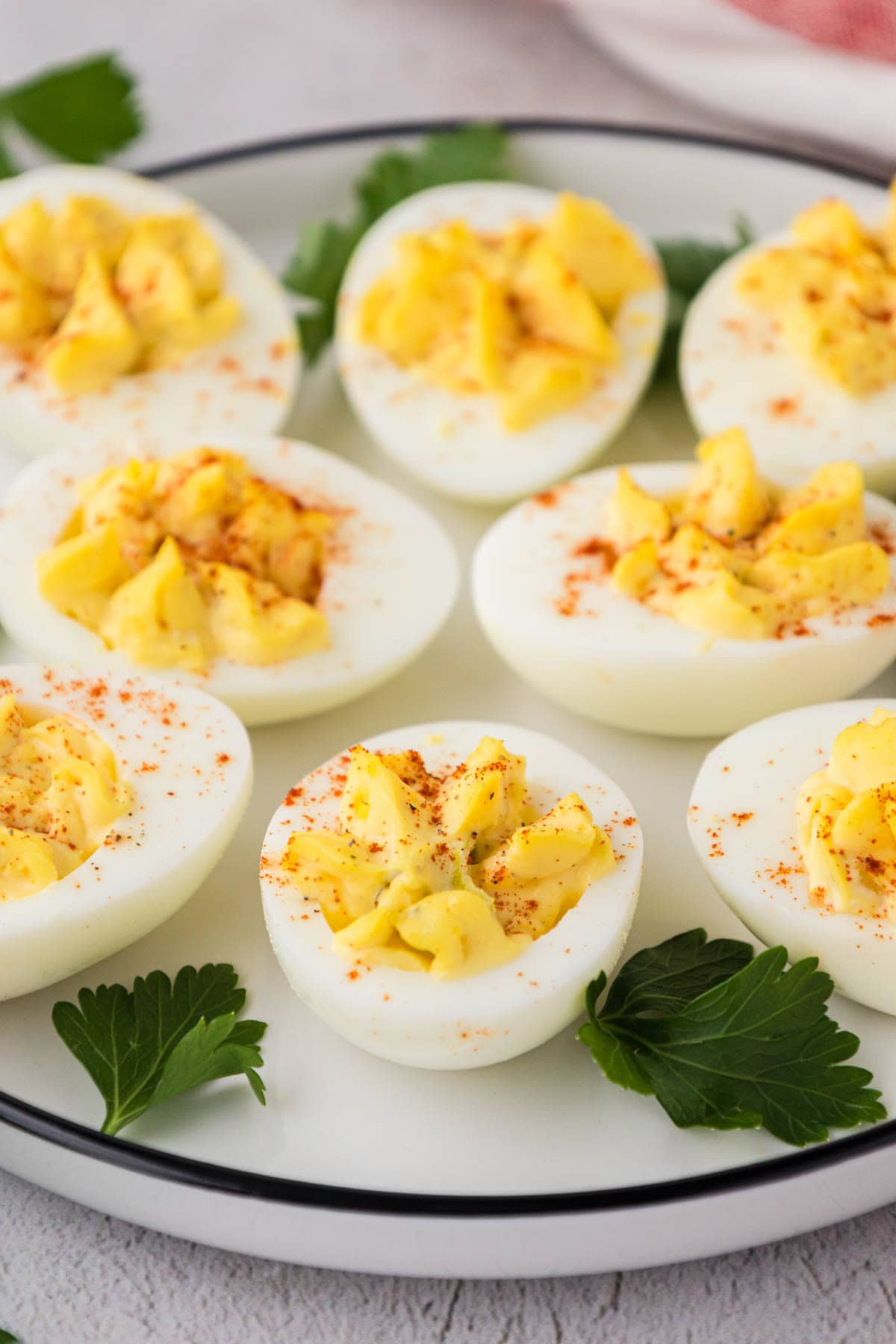 Deviled eggs on a white plate garnish with parsley.