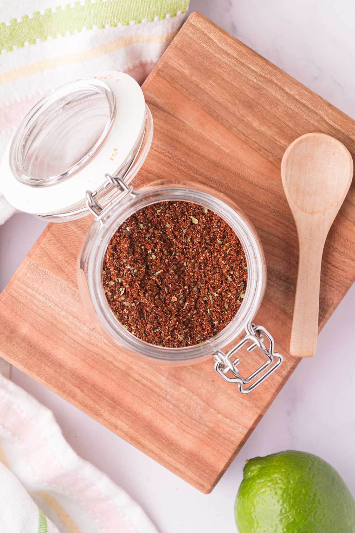 Mexican elote spice blend in a jar on a wooden tray.