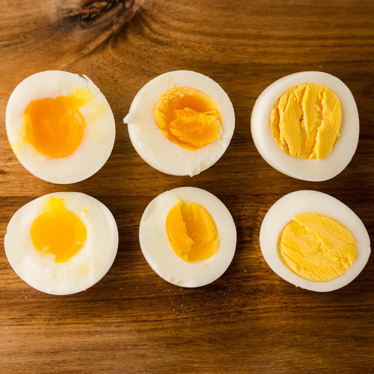 A wooden cutting board with sliced boiled eggs.