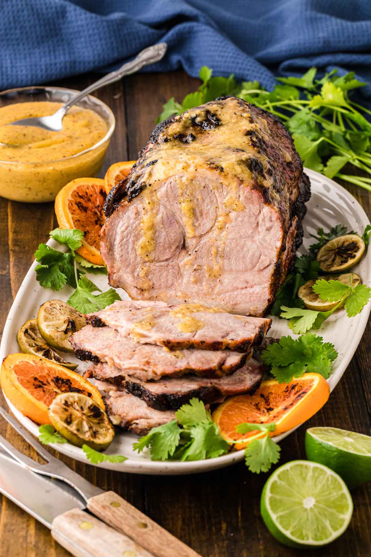 Roasted Cuban pork on a serving platter with mojo sauce drizzled over the top.