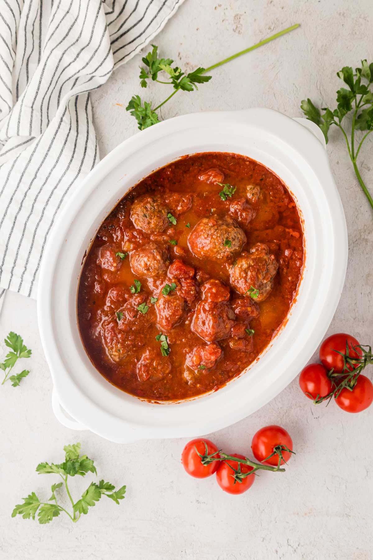Overhead shot of slow cooker Italian meatballs in a white crock pot.