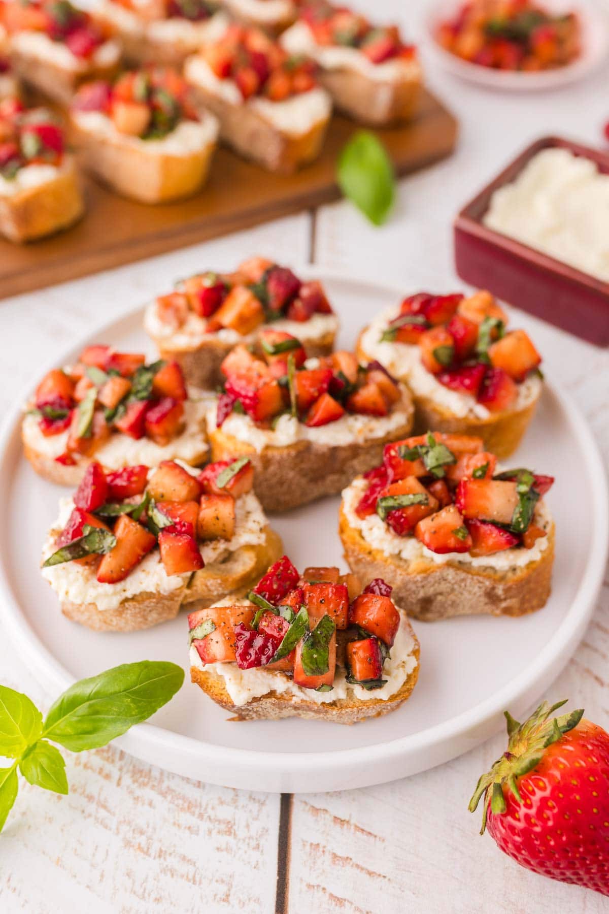 Strawberry ricotta bruschetta served on a white plate.