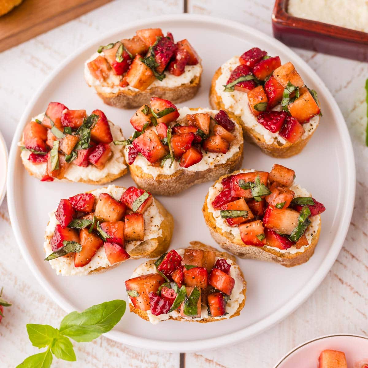 Overhead shot of strawberry bruschetta served on a white plate.