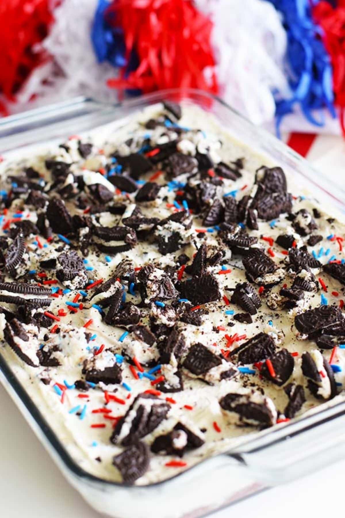 An overhead shot of these no bake fireworks oreo cheesecake bars with red, white, and blue sprinkles and chopped oreos on top.