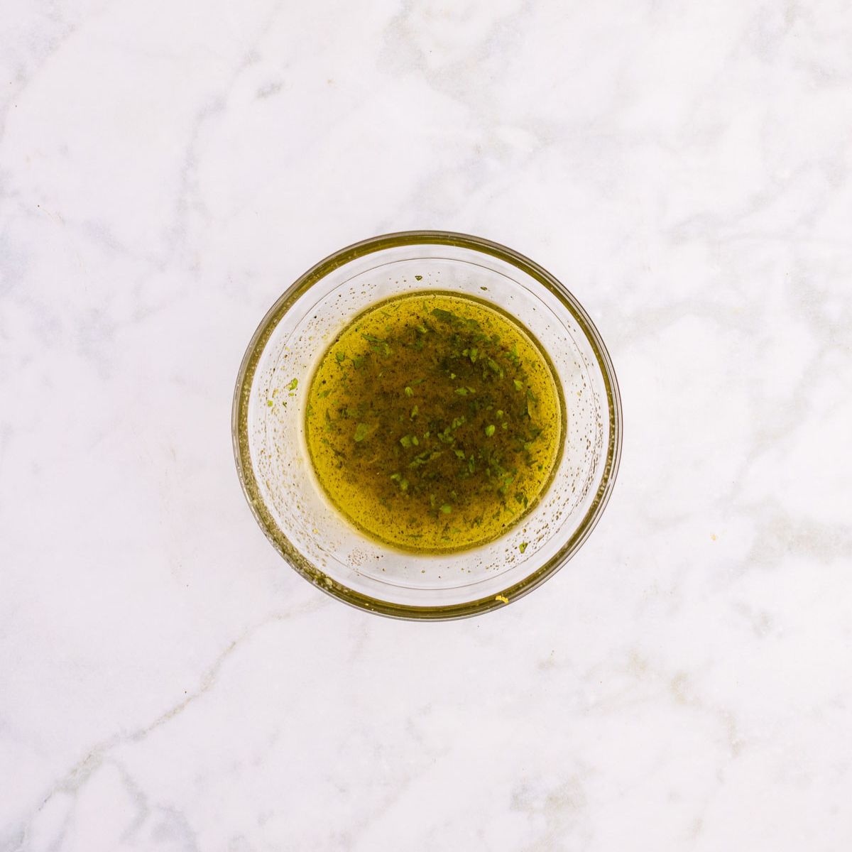 Greek roast chicken marinade in a glass bowl.