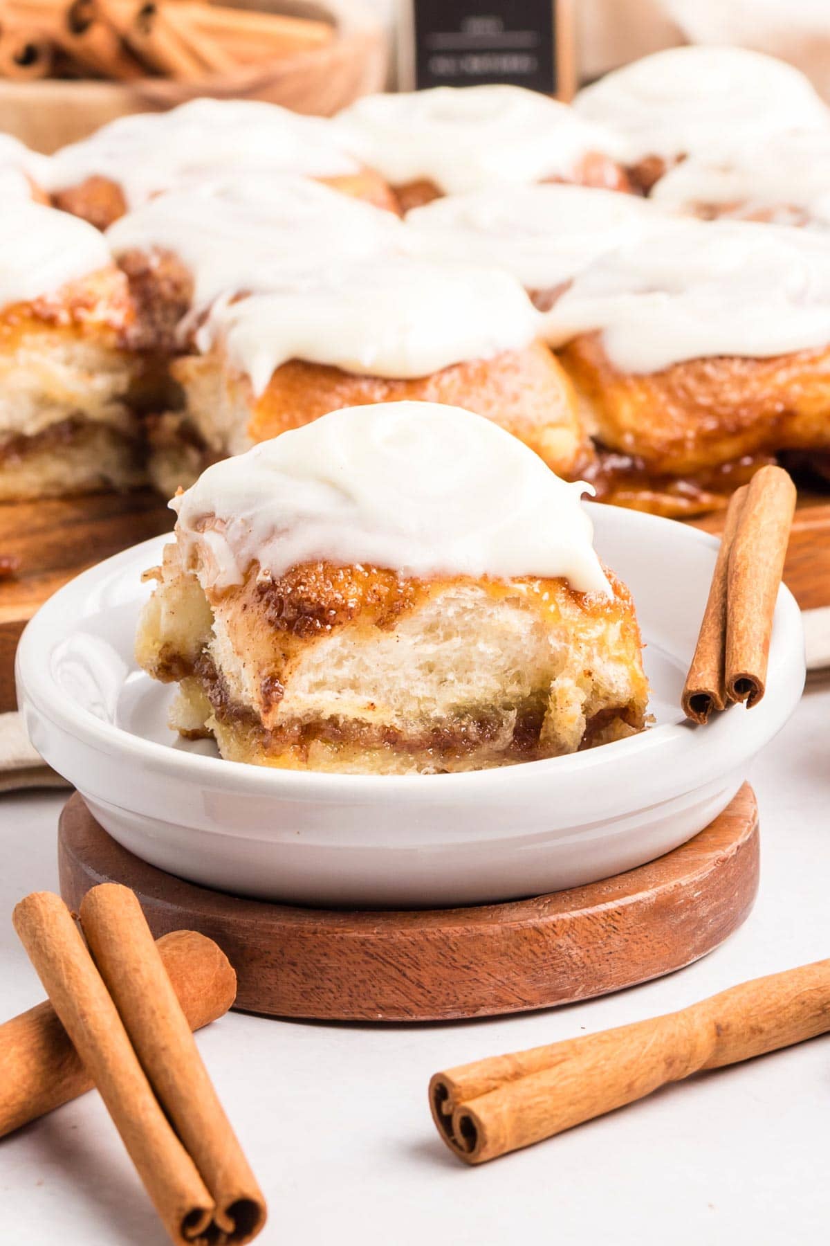 Hawaiian roll cinnamon roll served in a white bowl with more in the background.