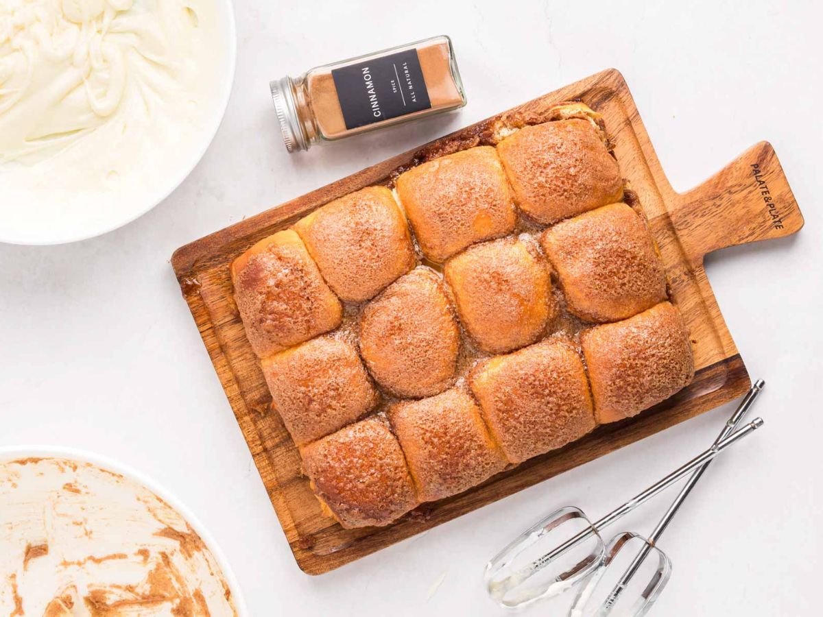 Hawaiian roll cinnamon buns after baking on a wooden board.