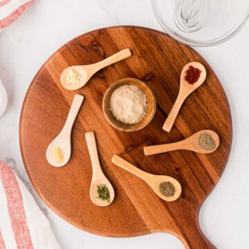 A wooden board with measured ingredients needed to make a homemade version of Lipton's french onion soup mix.