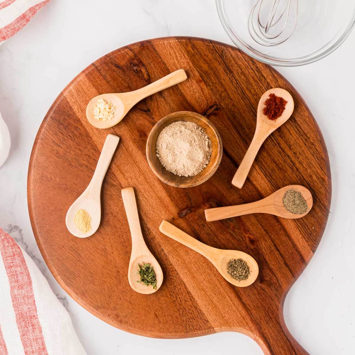 A wooden board with measured ingredients needed to make a homemade version of Lipton's french onion soup mix.