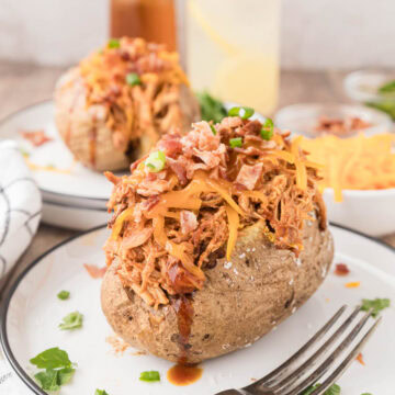 A loaded barbecue baked potato drizzled with barbecue sauce.
