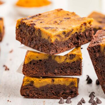 Close up of pumpkin brownies stacked on top of each other.