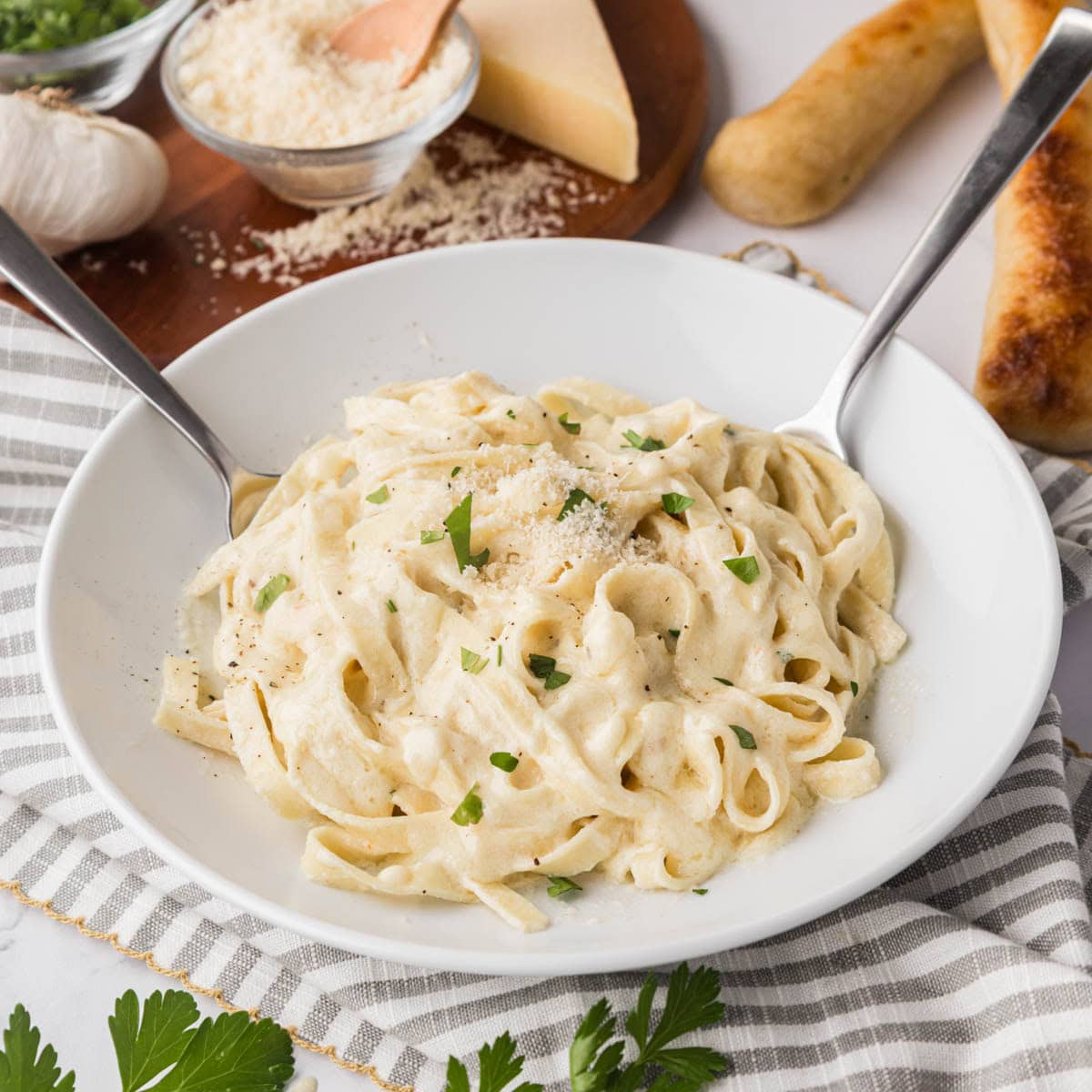 Fettuccine with homemade Alfredo sauce and a white bowl.