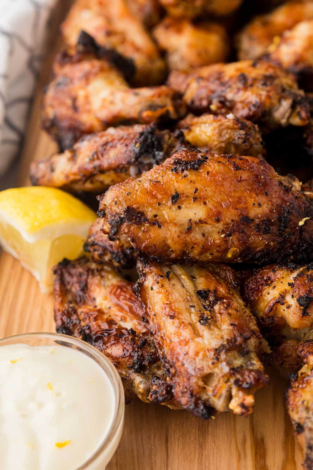 Wings with lemon butter sauce on a wooden serving board.