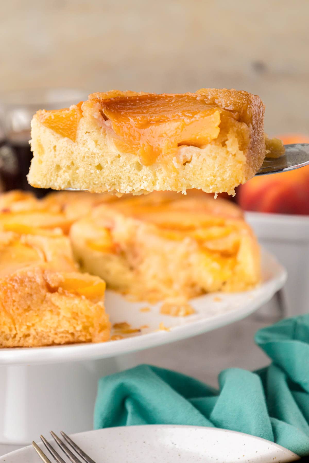 A slice peach cake on a cake serving spatula.