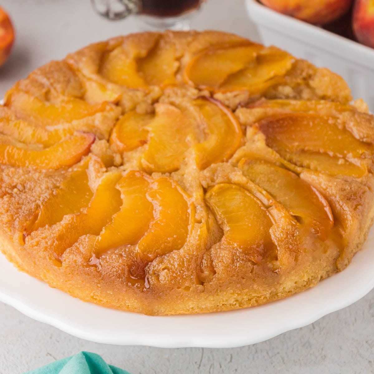 A peach upside down cake on a cake stand.