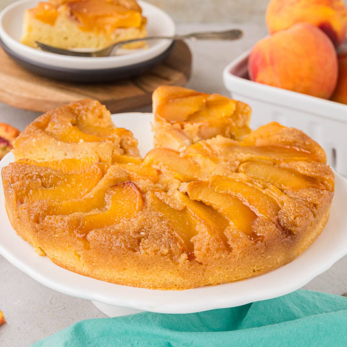 A peach upside down cake on a cake stand.