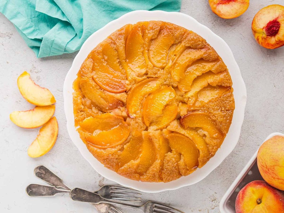 An overhead view of a peach upside down cake on a cake platter
