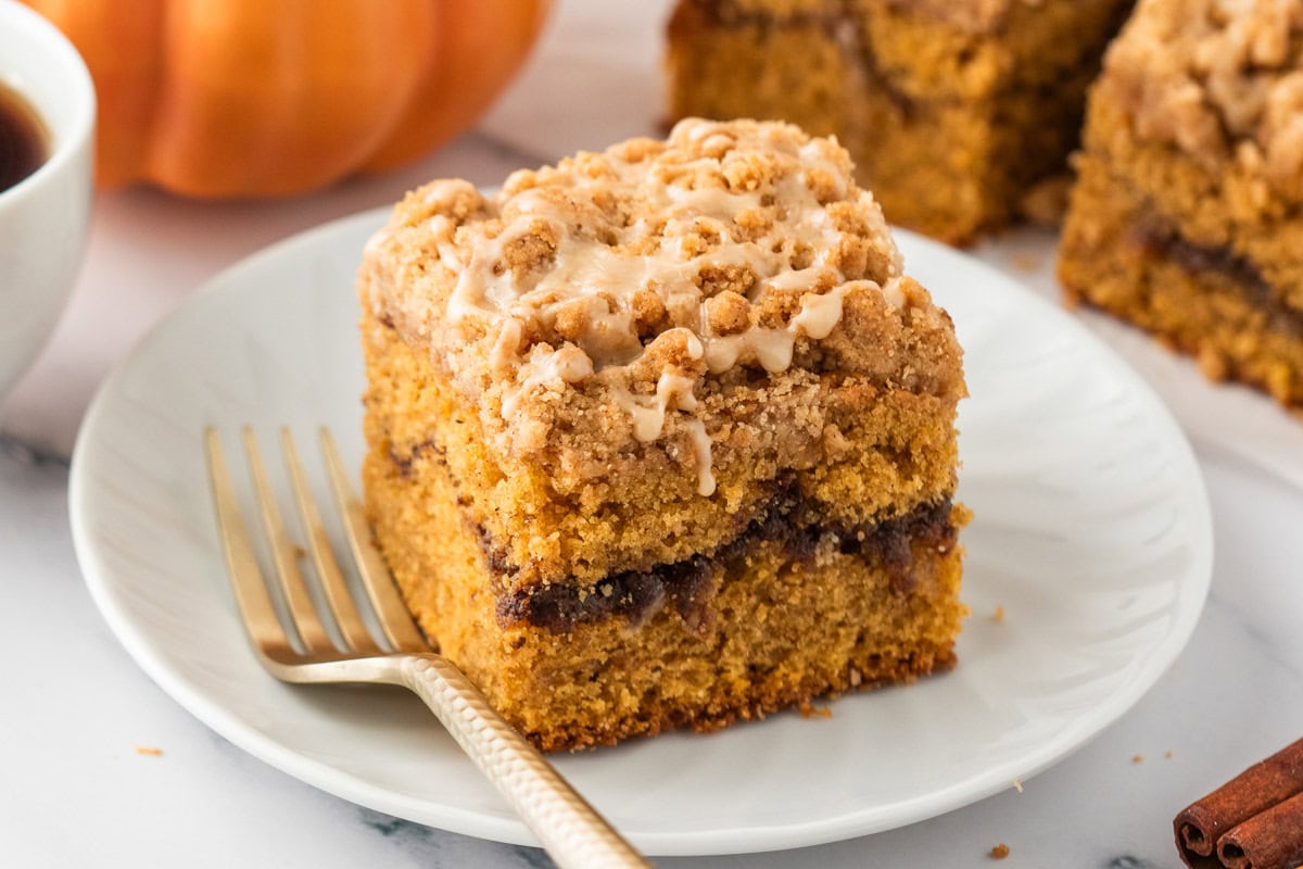 Slice of pumpkin coffee cake on a plate with a fork.