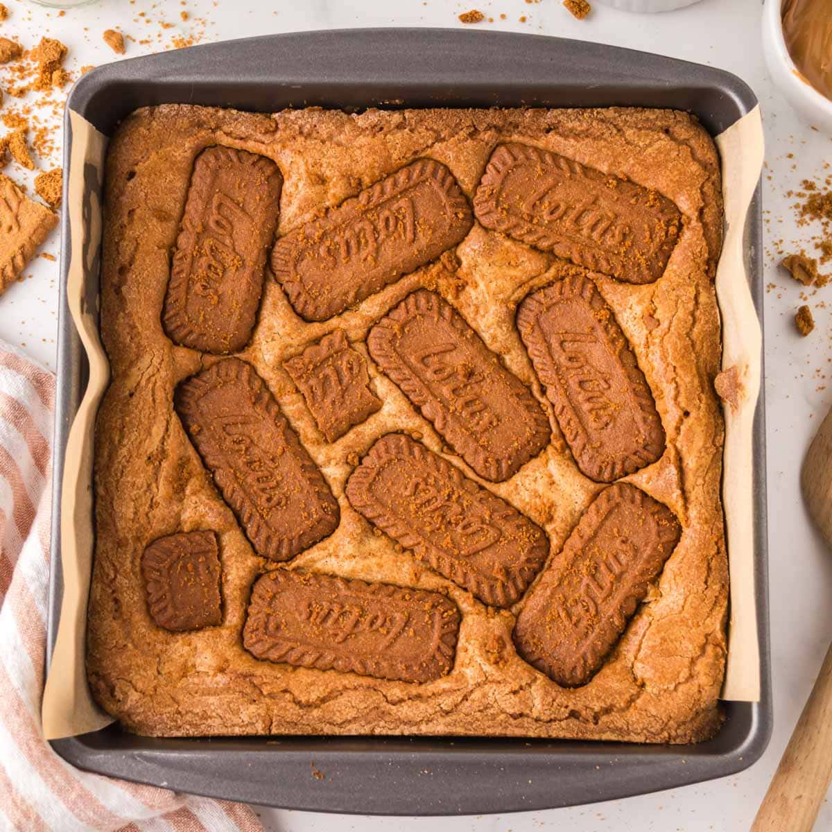 Biscoff blondies baked in a baking dish lined with parchment.