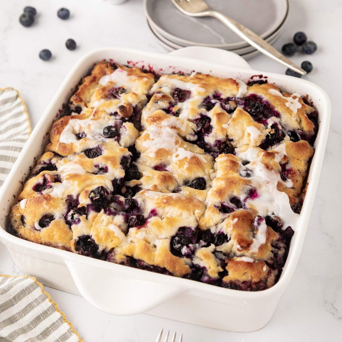 Blueberry butter, swim biscuits in a white baking dish.