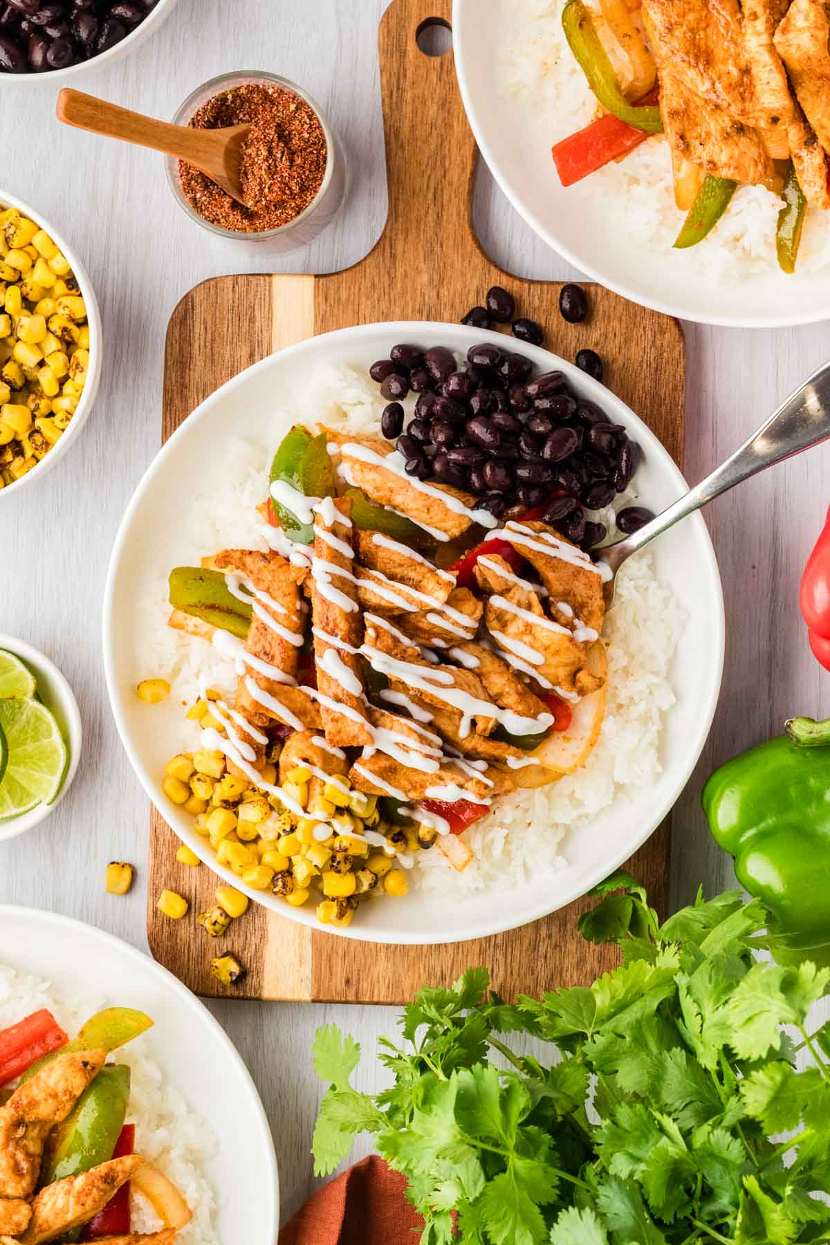 Overhead shot of a chicken fajita bowl served with black beans, corn, and sour cream.