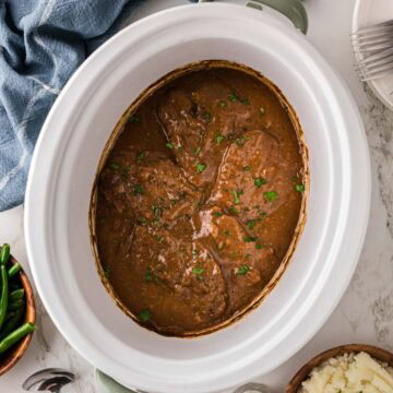 Cubed steak and gravy made in a crockpot, garnished with par