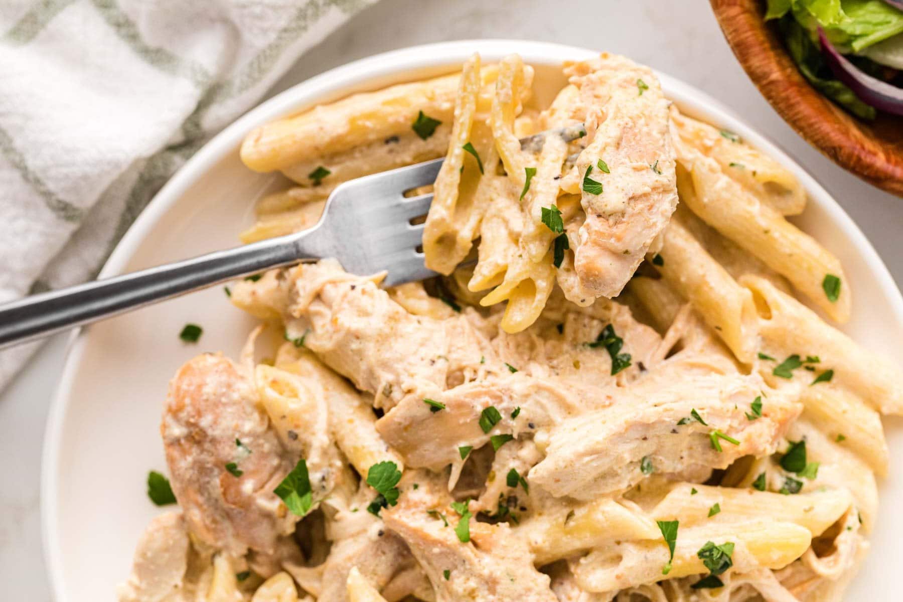 A fork taking a bit of pasta.