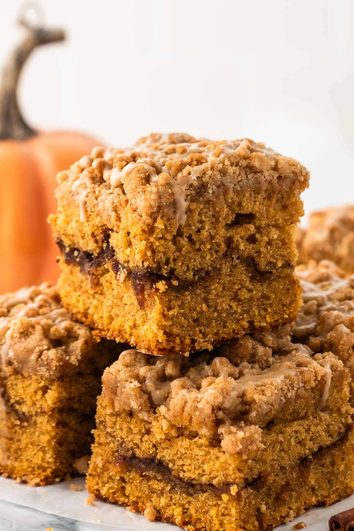 A slice of pumpkin coffee cake stacked on top of two more underneath it.