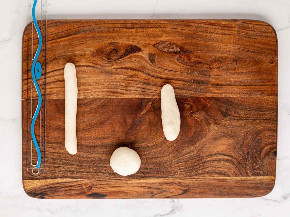 A wooden board showing the dough ball, and it being rolled into a breadstick shake.