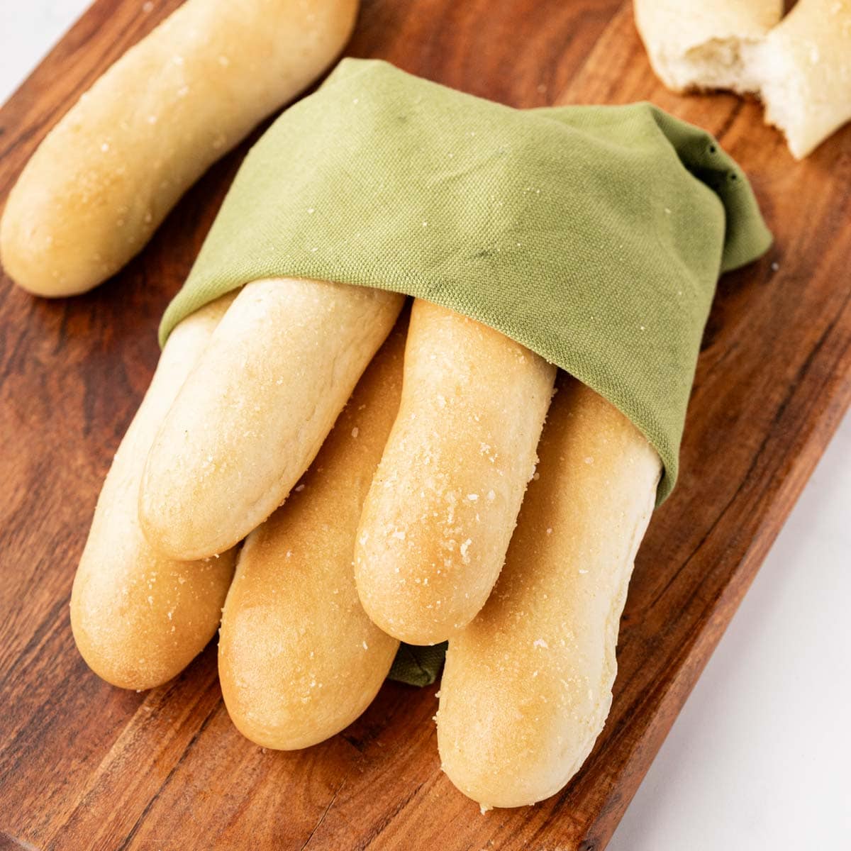 Breadsticks wrapped with a green napkin.