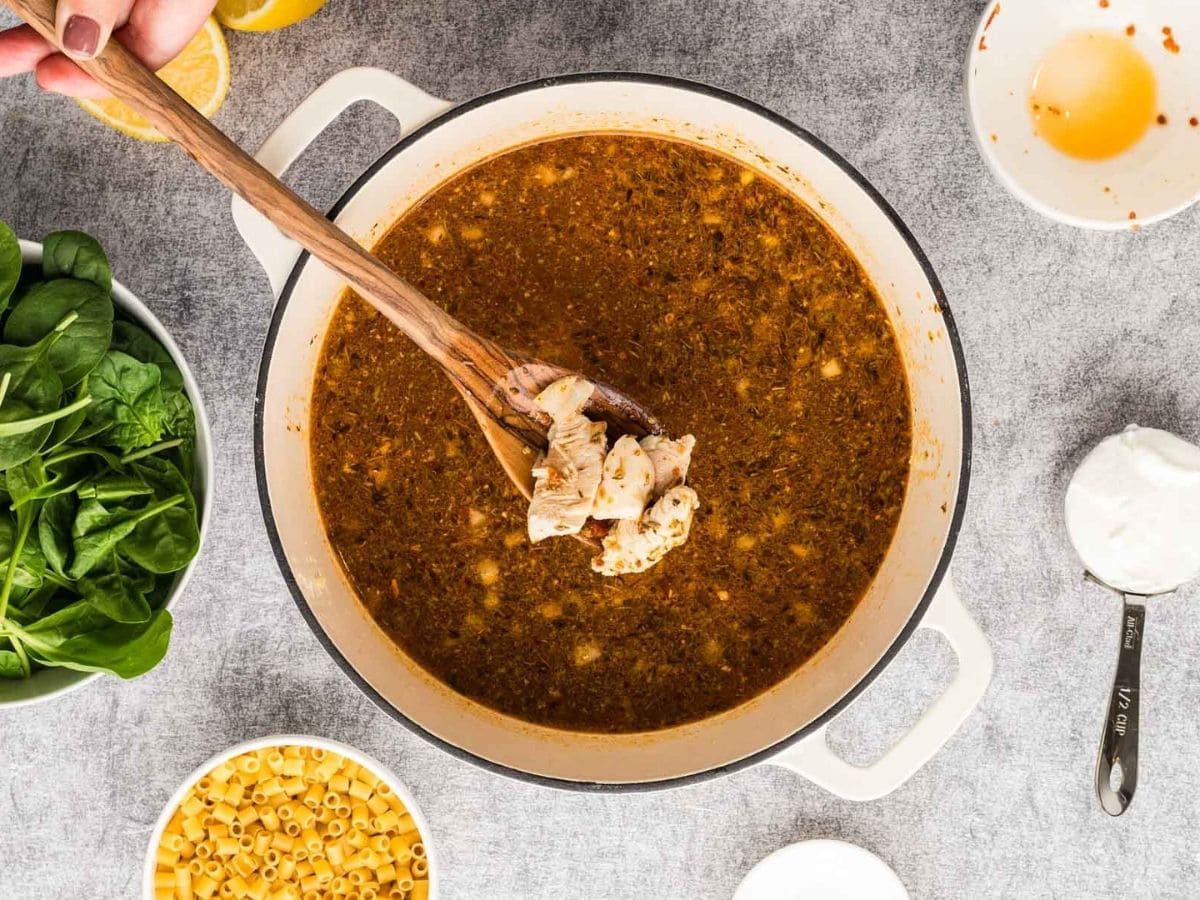 Adding the chicken back into the pot of soup.