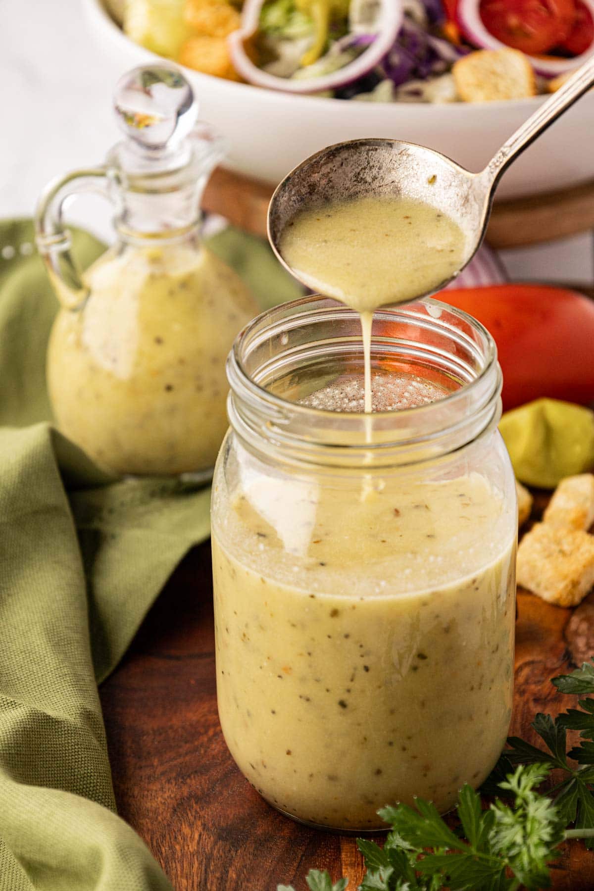 A ladle pouring the dressing into a jar.