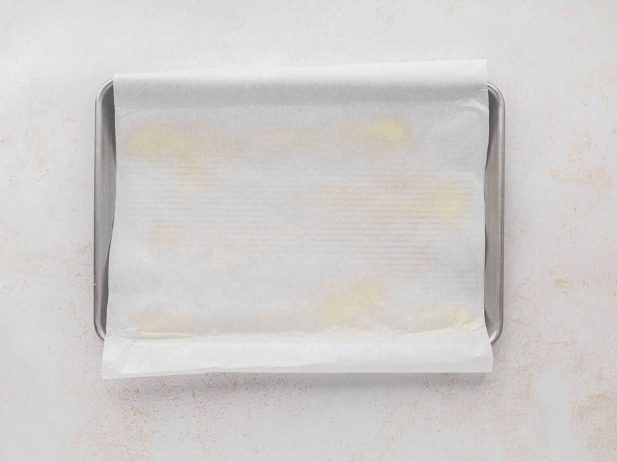 A jelly roll pan line with parchment paper and greased.