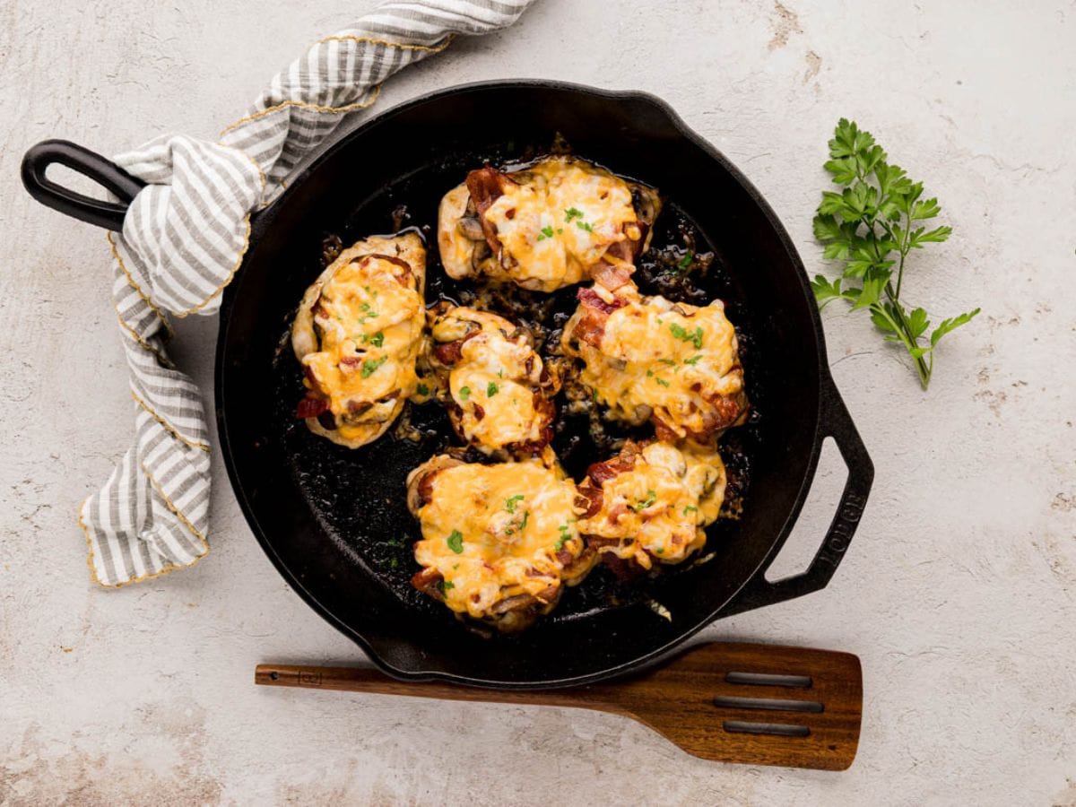 A cast-iron skillet with cooked alice springs chicken.
