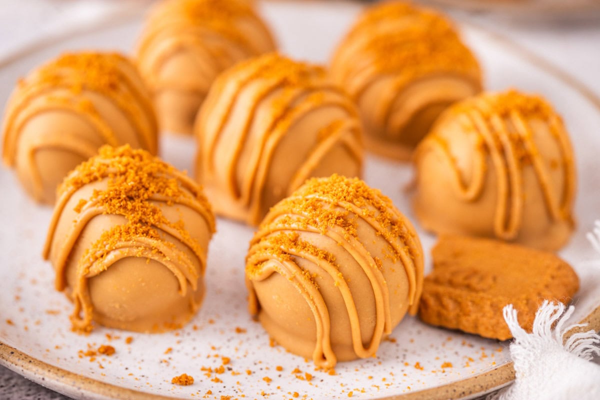 Biscoff truffles with cookie butter coating on a plate.