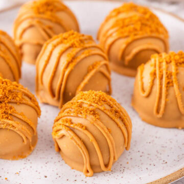 Biscoff truffles with cookie butter coating on a plate.