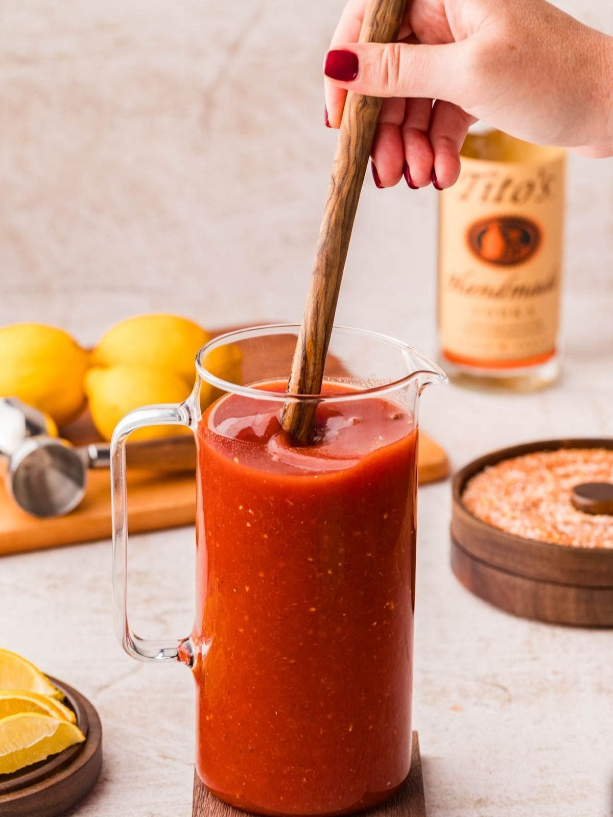 Stirring the blood mary mix with a wooden spoon.